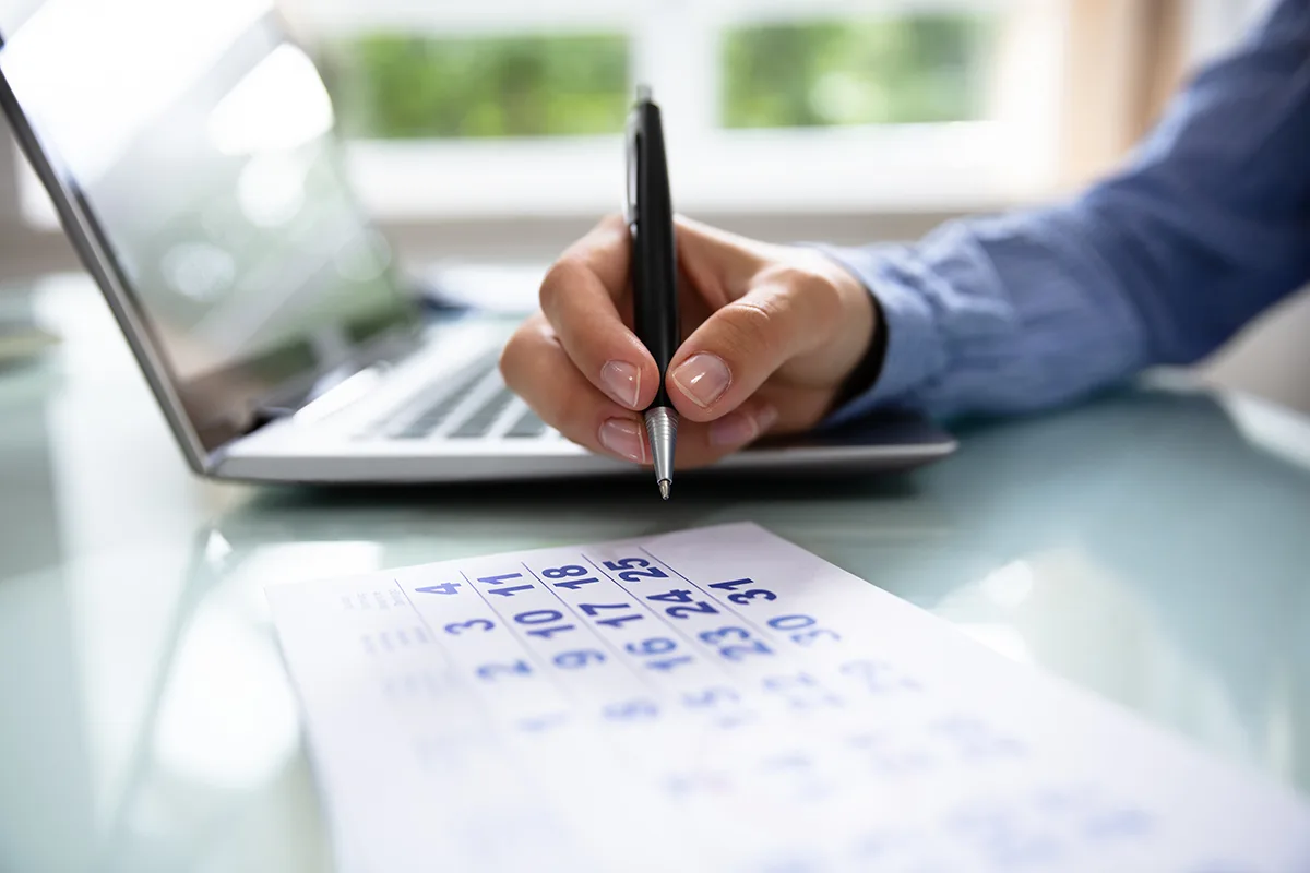Businesswoman Marking Date On Calendar