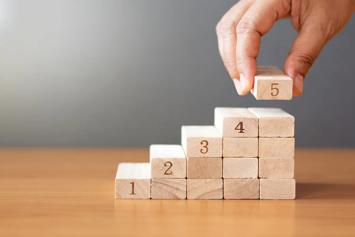 Women hand putting a wooden block on top and arranging wooden bl