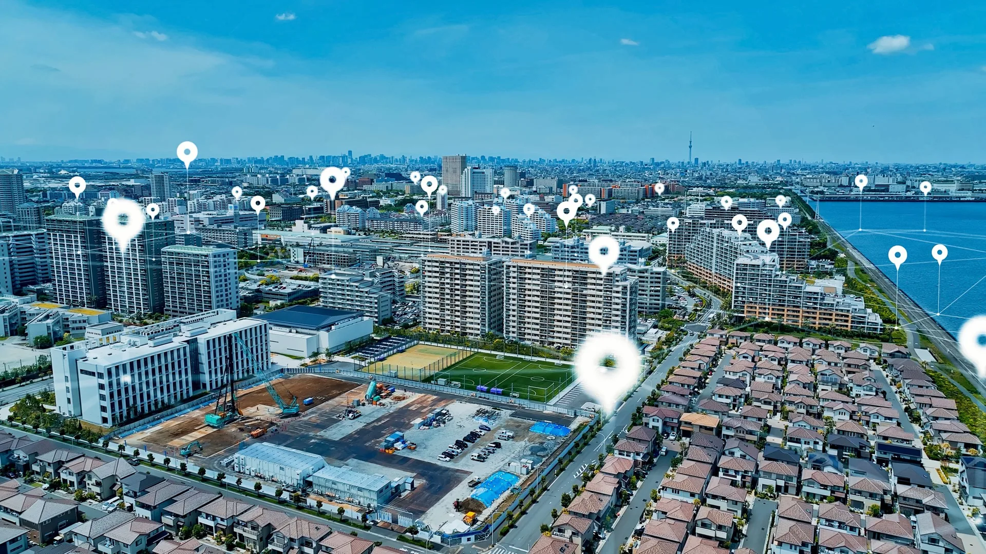 Aerial view of a dense urban area with digital map overlays highlighting property locations and boundaries